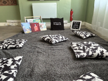 Photo of reading space with books and cushions.