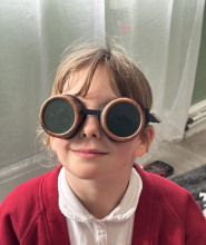 Child wearing dark-tinted goggles.