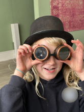 Child wearing dark-tinted goggles and hat.